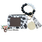 Wallet/Wristlet with Black and White Cow Print Cardholder with a Black and White Silicone Beaded Wristlet with Gold Hardware, Matching Tassel, and a Wooden Disc